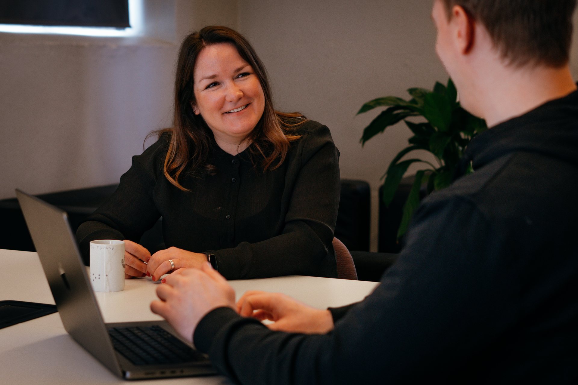 Smilende dame som er i kundemøte med Frame